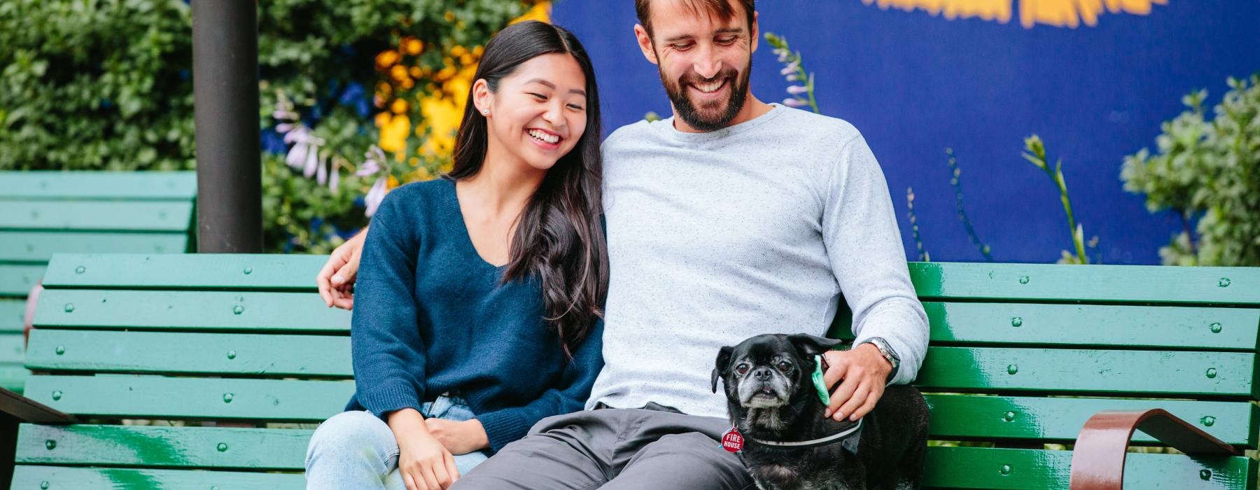 a couple sitting on bench with a dog J Malden Center luxury apartments Malden MA 