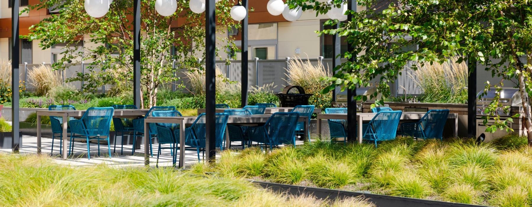 a group of tables and chairs in outdoor courtyard  J Malden Center luxury apartments for rent Malden MA 