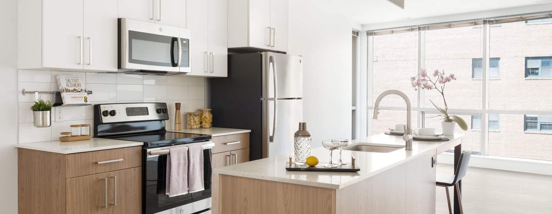 kitchen appliances with white cabinets and oversized windows J Malden Center luxury apartments Malden MA 