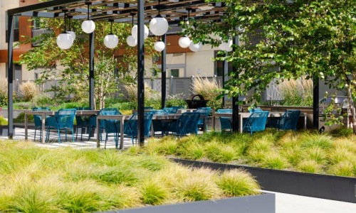 a group of tables and chairs in outdoor courtyard  J Malden Center luxury apartments for rent Malden MA 