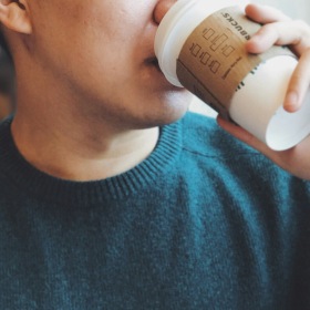 Apartments on Orange Line Boston man drinking a coffee indoors